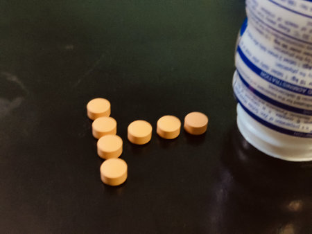 Medicine pills and bottle on black background. Focus on foreground.の写真素材