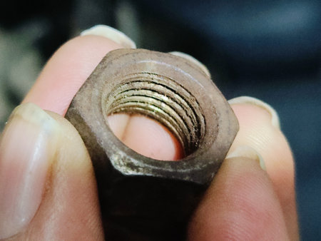 Bolt and nut in the hands of a man close-up