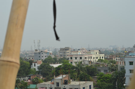 Overlooking a residential neighborhood, showcasing lush trees, small houses, and nearby city...