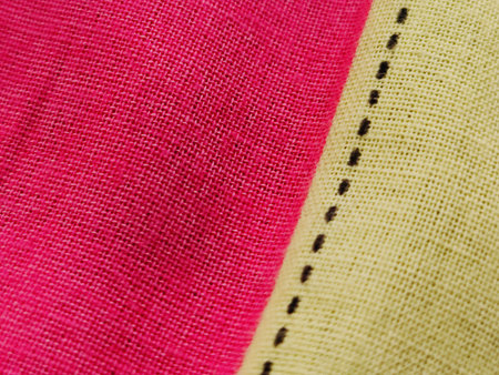 Closeup detail of pink and yellow fabric texture background. Macro.