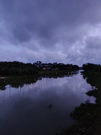 Sunset hues reflecting on a tranquil lake, bordered by lush greenery and trees. An idyllic setting...