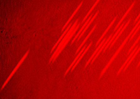 A vibrant abstract composition featuring red light streaks cutting diagonally across a textured red surface. Dynamic, modern, and bold, ideal for art, backgrounds, and design projects.の写真素材