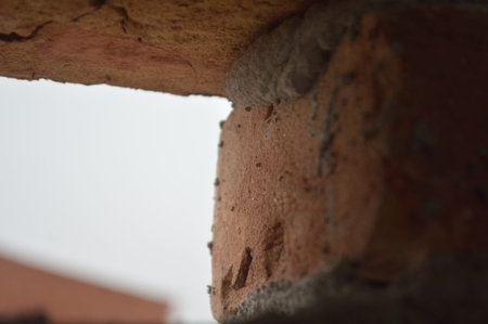 Moody architectural detail of a cracked concrete beam illuminated by a sliver of light inside an...