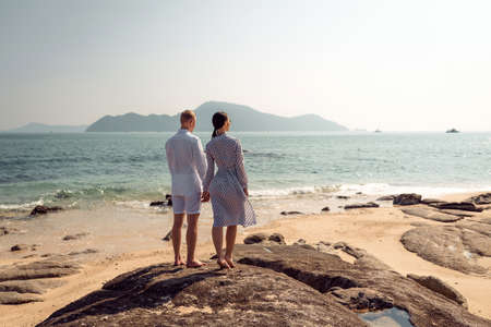 Happy couple standing on the rockの写真素材