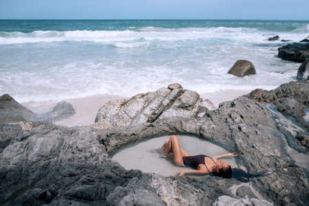 A traveler sexy woman resting on the Tropical island with white paradise sand beach and turquoise clear waterの写真素材
