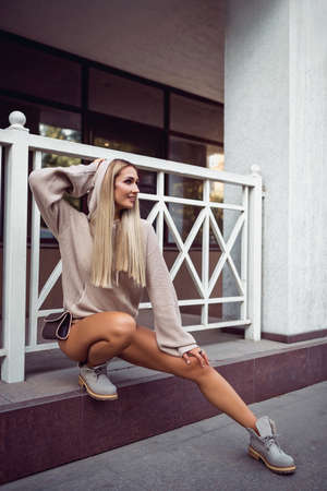 sexy blonde in beige lingerie and coat posing near the cafe. RESTの写真素材