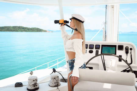 Attractive blonde at the wheel of a yacht