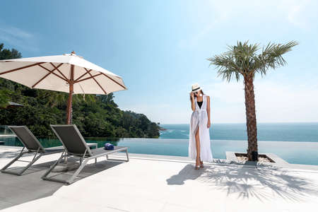 Superb sea view: a woman in a hat enjoys vacationの写真素材