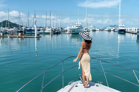 Young happy woman at the port of luxury yachts and shipsの写真素材