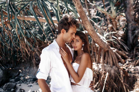 A couple in white clothes is resting on the beach of a wonderful islandの写真素材