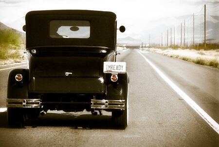 Classic Car driving along power poles on road to Paysonの写真素材