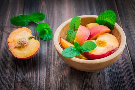 Peaches in a plate on a wooden background.の写真素材