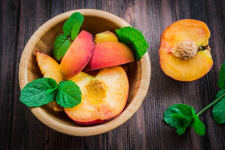 Peaches in a plate on a wooden background.の写真素材