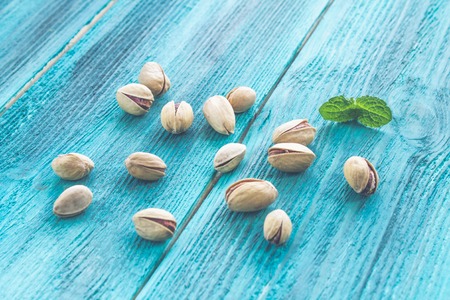 pistachios and mint on a wooden background.の写真素材