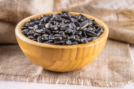 Fresh Sunflower seed. Shelled sunflower seeds in wood bowlの写真素材