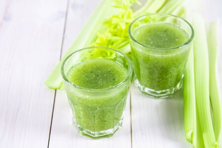 Vegetable cocktail made from celery leaves, healthy lifestyle on a white wooden backgroundの写真素材