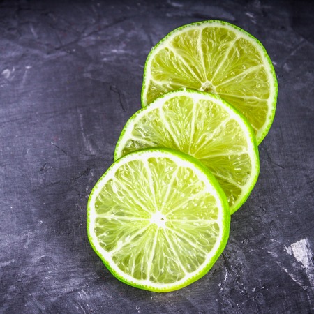 Slices of lime on a gray marble background.