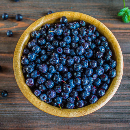 blueberries in a bowl on a wooden table.の写真素材