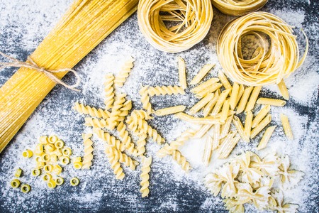 Various mix of pasta on a gray concrete background. Diet and food conceptの写真素材