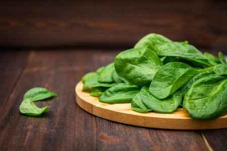 Fresh juicy spinach leaves on a wooden brown table. Natural products, greens, healthy food, vitamins.の写真素材