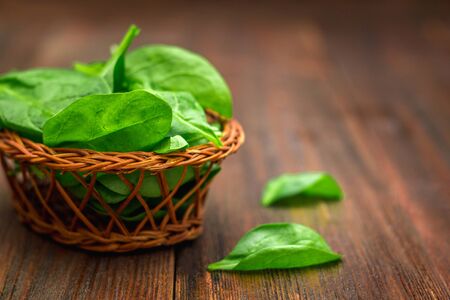 Fresh juicy spinach leaves on a wooden brown table. Natural products, greens, healthy food, vitamins.の写真素材