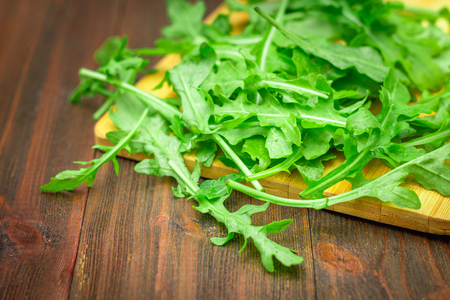 Fresh juicy leaves of arugula on a brown wooden table.の写真素材