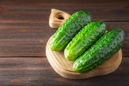 Fresh raw green cucumbers on a wooden tableの写真素材
