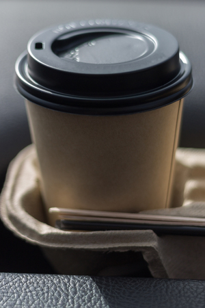 coffee take-away in a paper cup in the carの写真素材