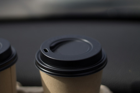 coffee take-away in a paper cup in the carの写真素材
