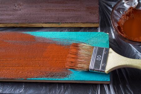 Brush with paint in hand. A man paints blue boards in a brown paint brush.の写真素材