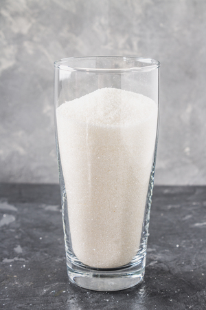 Glass with sugar sand is an unhealthy diet. The contents of sugar in sweet soda.の写真素材