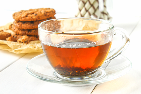 Homemade oatmeal cookies and tea on a wooden white tableの写真素材