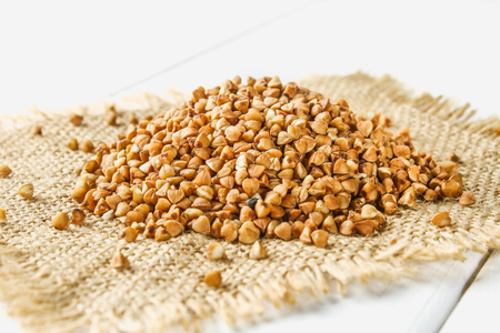 Raw buckwheat on a sack on a wooden table. Healthy diet foodの写真素材
