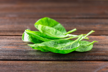 Green fresh spinach leaves on a wooden tableの写真素材