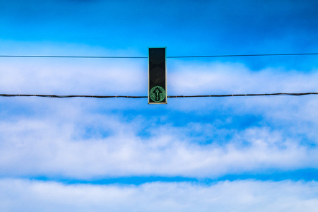 Three green traffic lights hang over the road against the blue sky. Allow signalの写真素材