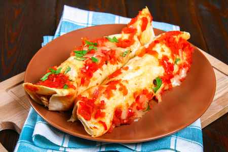 Homemade chicken enchiladas in dish on wooden table. Top viewの写真素材