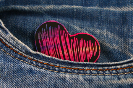 Heart - a symbol of love peeps out of the pocket of jeans trousers. The concept of the day of...