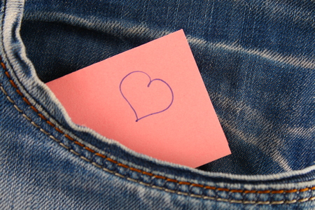 Heart - a symbol of love peeps out of the pocket of jeans trousers. The concept of the day of lovers. St. Valentine's Dayの写真素材