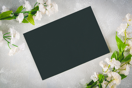 Chalkboard with an empty field surrounded by white flowers on a gray background. Copy the space. Template for spring or female holidayの写真素材
