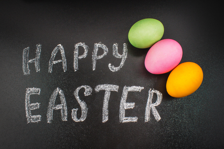 Chalk chalkboard Happy easter on a chalkboard and colorful eggsの写真素材
