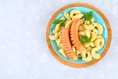Pasta Cavatappi or Cellentani with sausages on a gray tableの写真素材