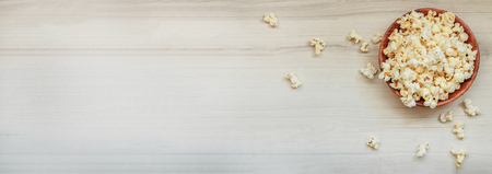 Salted popcorn on a wooden table. Banner for website, advertisingの写真素材