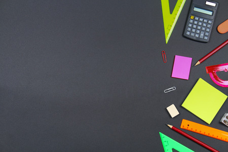 School and office supplies on blackboard background. Top view with copy spaceの写真素材