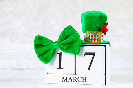 St.Patrick 's Day. A wooden calendar showing March 17. Green hat and bowの写真素材