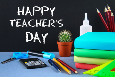 Text chalk on a chalkboard: Happy Teacher's Day. School supplies, office, books, appleの写真素材