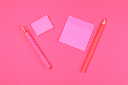 Pink felt-tip pen, pencil and sheets for notes on a pink pastel background. Summer. Top view. Flat lay. Copy spaceの写真素材