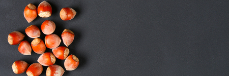 Top view of roasted peeled hazelnuts on a saturated black background.Snacks. Copy space