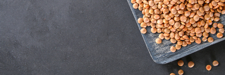 Raw red lentils on a wooden board. Superfoodの写真素材