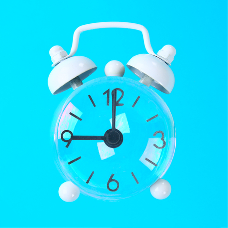 Soap bubbles with arrows in the form of a clock on a blue pastel background. Minimalism. The concept...