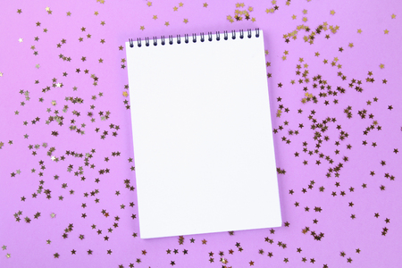 An empty pad on a pastel background surrounded by shiny decorative stars and ballsの写真素材